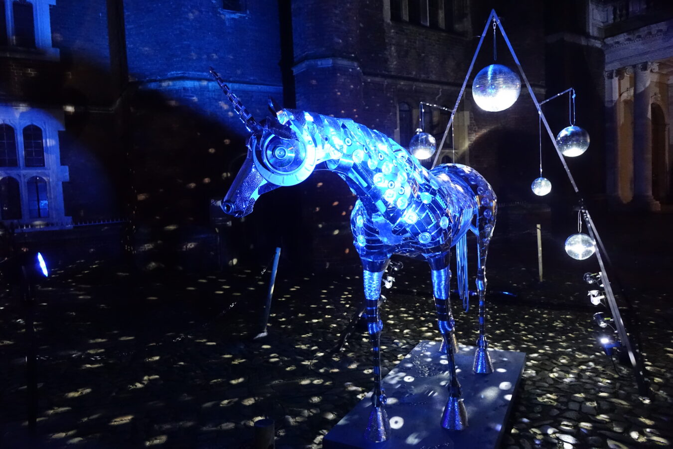 A unicorn made of silver circle shapes in lit up in blue lights.